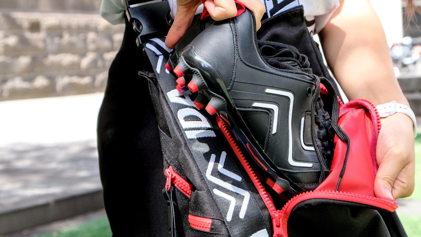 person pulls soccer cleats out of an Ida Boot Bag
