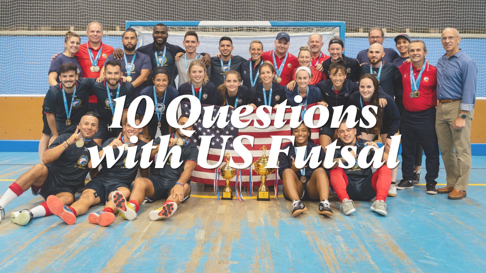 Group photo of futsal players on the US Futsal Women's and Men's National Teams wearing Ida Spirit and holding a US flag behind their trophies from the IFA World Championships