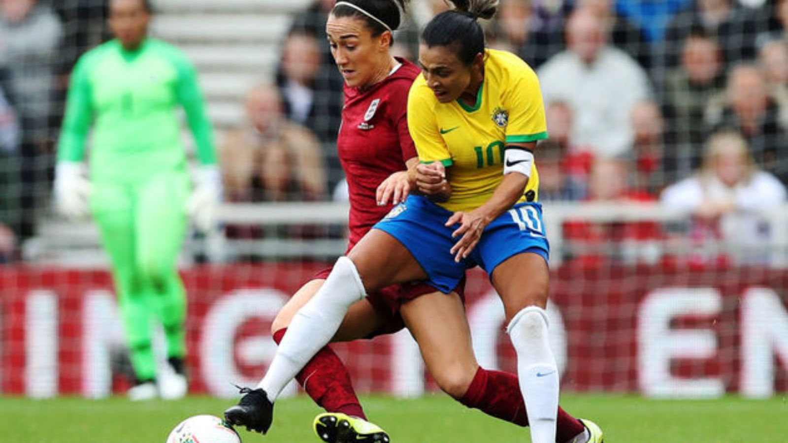 marta and lucy bronze reach for a ball in a soccer game